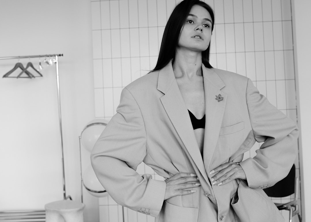 Woman poses confidently in a blazer and bra