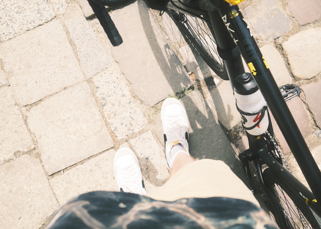 a person standing next to a bike on a sidewalk